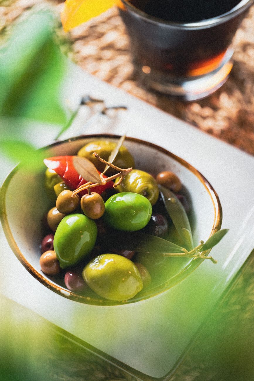 Rustic table setting with wild olives and Mediterranean ingredients